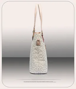 Side view of cream tote bag with brown hook patterns and golden metal hardware detail