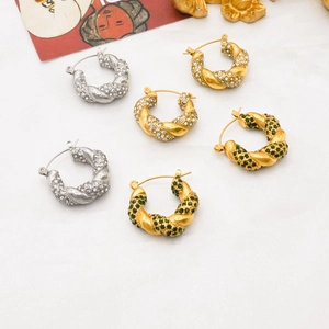 Detailed overhead view of 18K gold and silver twisted U-shaped earrings with zircon inlay