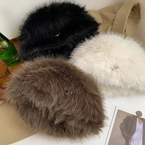Flat lay of soft faux fur bucket hats in black, beige, and brown for winter warmth