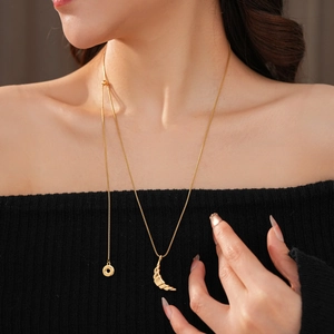 Detail of 18k gold plated crescent moon pendant on fine chain with ribbed texture