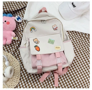 Detail view of beige and pink canvas backpack with cute cartoon bear and rainbow patches