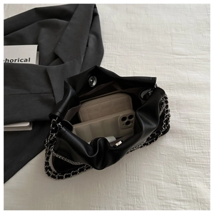 Top-down view of black ruched cloud bag interior showing space for phone and wallet