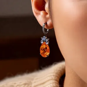 Vintage style zircon teardrop drop earrings with orange pear-cut stone on a model