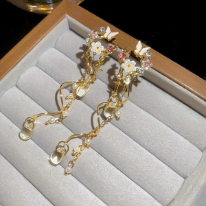 Close-up of luxury flower tassel earrings with crystals and pearl drops in a gift box