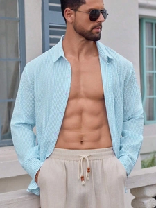 Detail of light blue striped seersucker shirt fabric paired with beige linen trousers