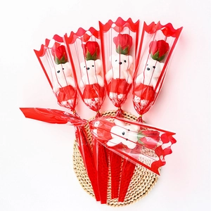 Detail of five single red rose soap flowers with cute white bears in red gift wrap