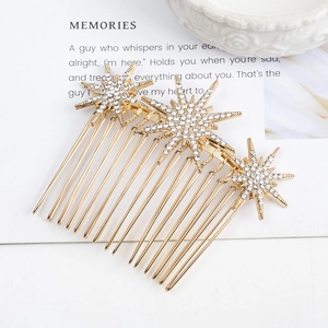 Golden alloy star-shaped hair comb with sparkling rhinestones on a decorative card