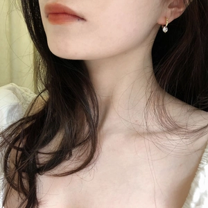 Close-up of S925 silver hoop earring with sparkling zircon stone on a female model