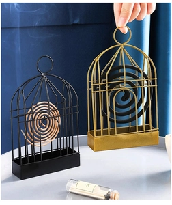 Detail of birdcage-shaped iron mosquito coil holder in golden and black finishes