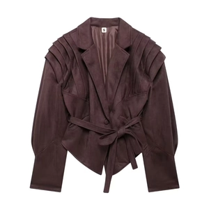 Détail de la veste en daim bordeaux avec épaules à volants et ceinture à la taille