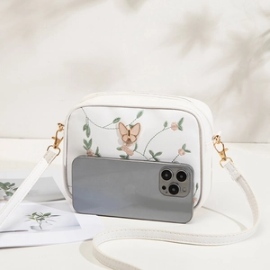 White faux leather crossbody bag with floral embroidery and butterfly metal clasp