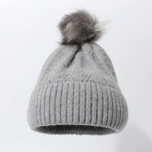 Thick grey cable knit winter beanie with a fluffy faux fur pompom for cold protection
