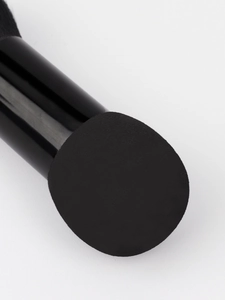 Macro shot of dual-ended makeup brush showing fine sponge texture and glossy black handle