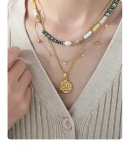 Detailed layered necklace set featuring green beads, triangle charms, and engraved disk
