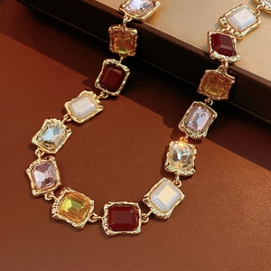 Close-up of vintage square multi-colored gemstone necklace with hammered gold finish