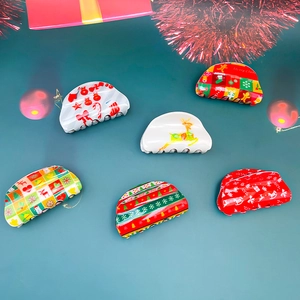 Festive Christmas hair claw clips set with reindeer and snowflake prints on green background