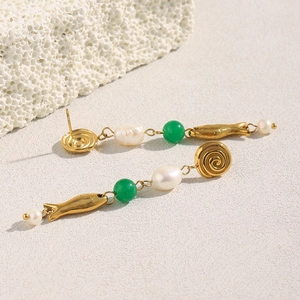 Detail of 18K gold-plated earrings with irregular pearls and green beads on a stone