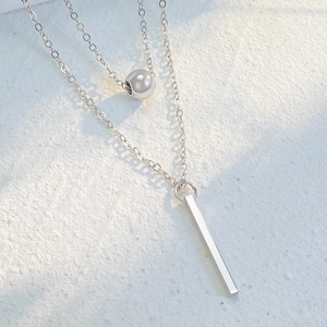Detail of silver double layer necklace with small round bead and vertical rectangle pendant