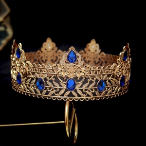 Detailed close-up of a vintage baroque gold crown featuring intricate blue rhinestones