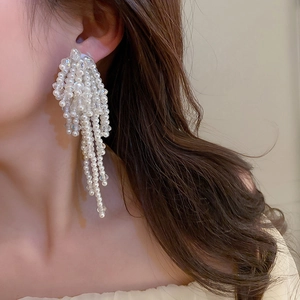 Gros plan de boucles d'oreilles pendantes à franges avec perles nacrées étagées