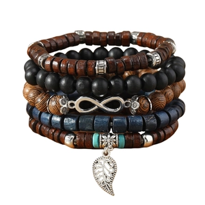 Close-up of multilayer beaded bracelets with wood beads, leaf charm and infinity symbol