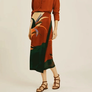 Detailed view of women's midi skirt with artistic tropical print and silky texture