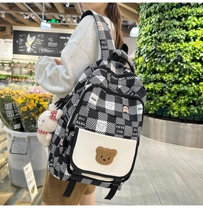 Detail of checkered backpack with bear patch, bunny charm and BAG NANA lettering