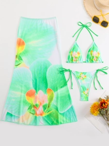 Detail of three-piece green floral bikini set with matching mesh sarong for summer beach