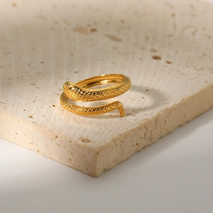 18K gold plated stainless steel snake ring with textured scales on stone background