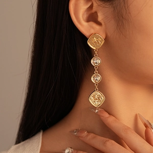 Detail of vintage gold drop earrings with clear crystals on a model for an elegant look