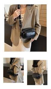 Detail of black pebbled PU leather camera bag with stylish wide strap and double zippers