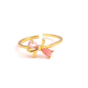 Vue détaillée d'une bague papillon dorée avec zircon rose et anneau ouvert ajustable