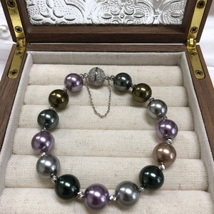 Detail of multi-color pearls bracelet with crystal-pave magnetic buckle in wood box