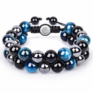 Detail of beaded bracelet with blue cat eye stones, metal beads and Om symbol