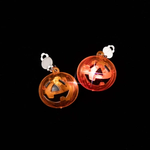 Detail of LED pumpkin clip-on earrings for Halloween with glowing Jack-o'-lantern design