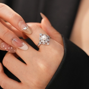 Detail of vintage hollow flower ring with white pearl and pave zircon on hand
