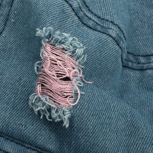 Blue denim bucket hat with distressed ripped details and pink inner frayed yarn accents