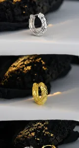 Detail of S925 silver hoop earrings with irregular lava texture in gold and silver