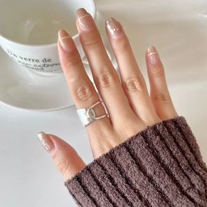 Close-up of minimalist silver wide band ring worn on hand with chic lifestyle background