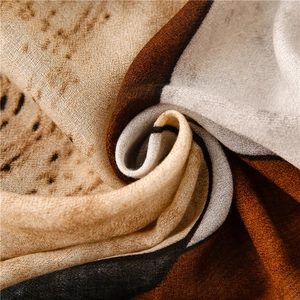 Detailed macro view showing the soft ink-wash texture and earthy pattern of the cotton scarf