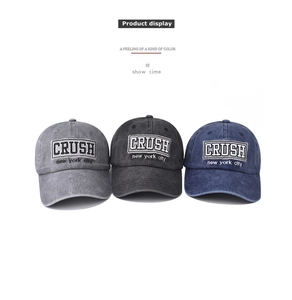 Detail of washed cotton baseball caps with CRUSH embroidery in grey, black and blue