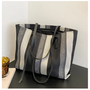 Detailed view of the vertical striped tote bag showing woven texture and slim shoulder straps