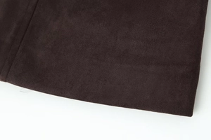 Gros plan sur la texture du daim marron foncé et les détails des fibres de cette veste