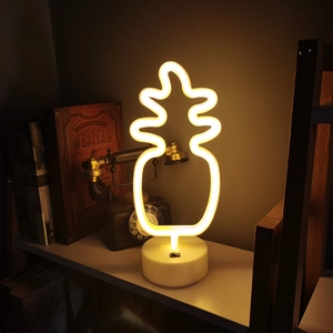 Pineapple LED neon light with white base on wooden shelf, warm yellow ambient bedroom lamp