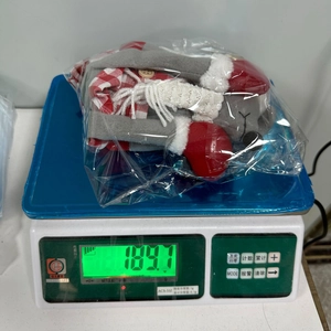 Dettaglio della bambola topo di Natale con tessuto a quadri rossi e bottone in legno