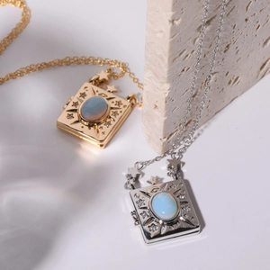 Detailed macro view of gold and silver square locket necklaces with opal inlay