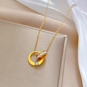 Macro detail of gold double-ring necklace with clear zircons on premium silk