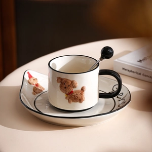 Detail of a beige ceramic coffee cup set with 3D cartoon dog and black ball spoon