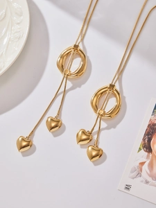 Detail view of gold heart pendant necklace with sleek snake chain and circular slide clasp