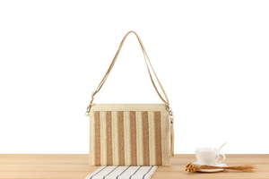 Detail of paper rope woven crossbody bag with vertical beige and brown stripes